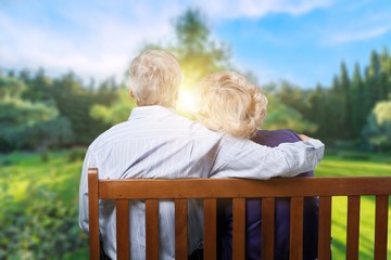 Portrait of happy senior couple in green blurred park background