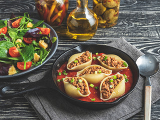 cooked pasta conchiglioni stuffed minced meat, tomato sauce