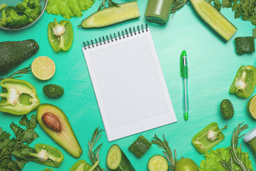 Fototapeta na wymiar Green vegetables with a note book for the inscription. To prepare a healthy and healthy meal. Healthy green vegan cooking ingredients. Banner for design. Top view, Flat-lay