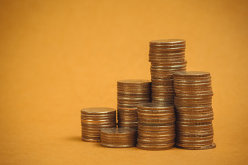Columns of coins, piles of coins on brown background, business and financial concept.