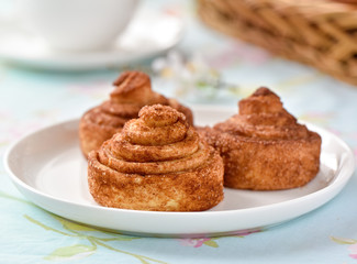 Cinnamon buns with tea and spring flowes on a table