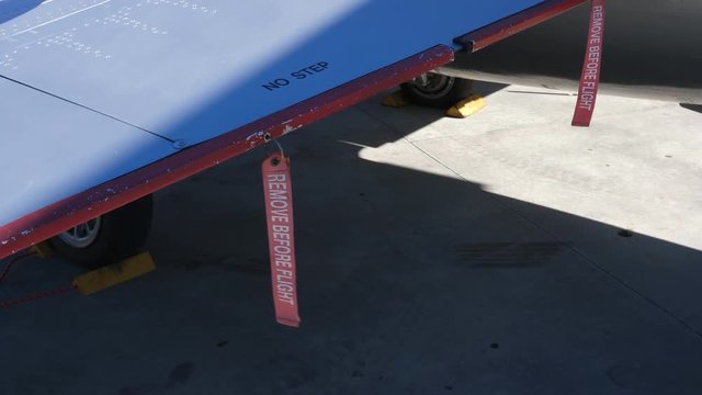 REMOVE BEFORE FLIGHT red ribbon tags on wing of military fighter jet. F-104 Starfighter.