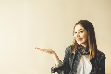 Pretty young woman gesturing with hand and showing copy space.