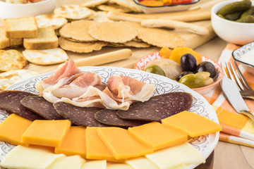 Assorted crackers, potato chips, mini party toasts and variety cheese and meat plate.