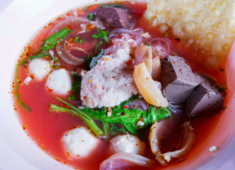 noodles with seafood on red soup / hot and spicy thai food noodle seafood squid pork fish ball