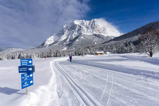 Winter mountain landscape with groomed ski trails and blue sky in sunny day. Ehrwald valley, Tirol, Alps, Austria, Zugspitze Massif  in background.