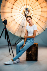 Model posing in front of a reflective umbrella in a studio