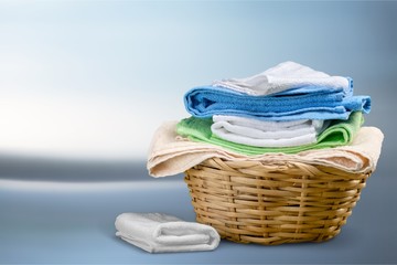 Laundry Basket with colorful towels on background
