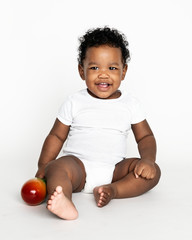 Baby sitting on the floor in a studio © Rawpixel.com