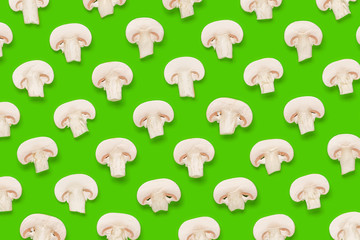 Fototapeta premium Food pattern of champignon slices on green background. Flat lay, top view. Mushroom background.