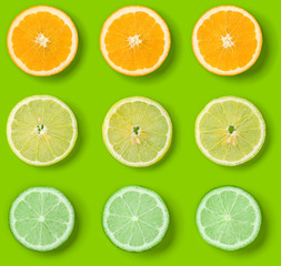 Fototapeta premium Citrus Fruits pattern on green background. Orange, Lime, Lemon slices background. Flat lay, top view.