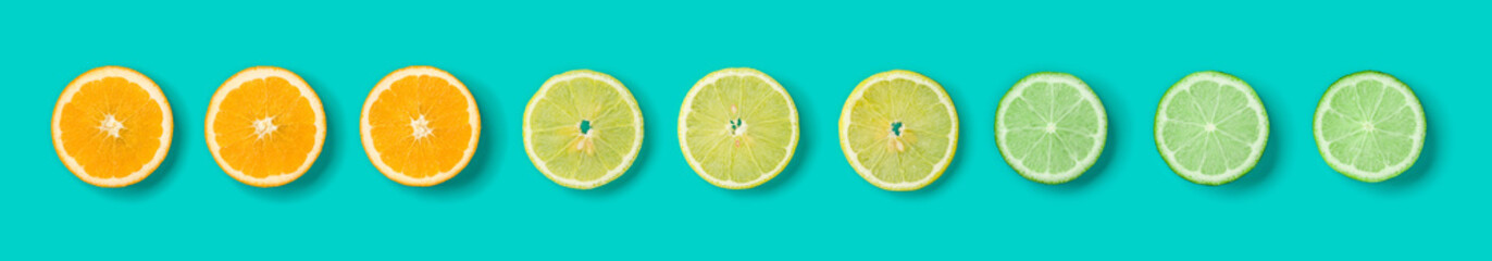 Citrus Fruit pattern on blue background. Orange, Lime, Lemon slices background. Flat lay, top view. Banner, seamless pattern, creative summer food concept.