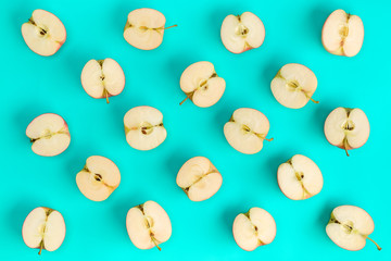 Fruit pattern of apple halves on blue background. Flat lay, top view. Food background.