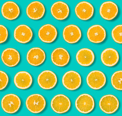 Seamless pattern of orange fruit slices on blue background. Flat lay, top view. Food background. .  Pop art design, creative concept.