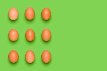 Eggs pattern on green background. Easter concept. Flat lay, top view. Food background. Copy space.