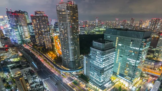 Timelapse Overview of City Transit below Tokyo Skyline at Night -Pan Right-