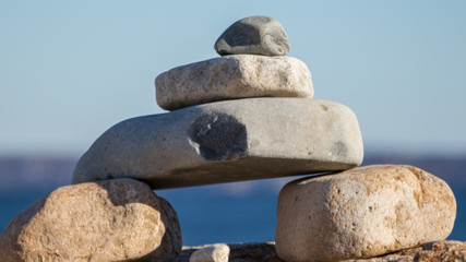Fototapeta na wymiar little stone inukshuk pile closeup, beach, sand, rocks, stones, art