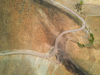 An aerial view from the drone of a road in Atacama Desert, Chile, the road make bends around the arid landscape in order to go down on the cliff to get to the beach, amazing textured pattern
