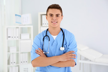 Young medical assistant with stethoscope in clinic