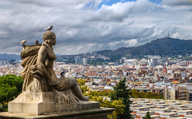 Statue of a woman against the panoramic city view form the National museum of Catalan on Montjuic hill. Barcelona, Spain.