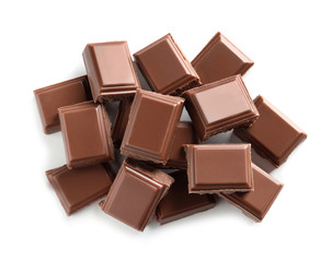 Pieces of tasty milk chocolate on white background, top view