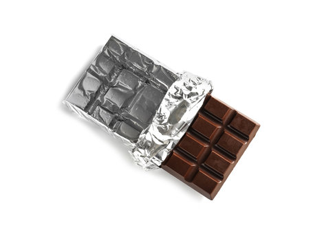 Tasty dark chocolate bar with foil on white background, top view