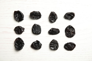 Flat lay of dried plums on wooden background. Healthy fruit