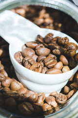 ose up Roasted coffee beans in container, spoonful of bean