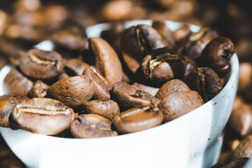 ose up Roasted coffee beans in container, spoonful of bean