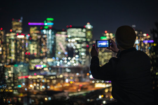 Bright City Lights Bokeh Background to Silhouette of Man Taking Smartphone Photography