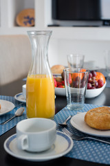 Plate with fresh crusty bread and glass of juice on white plate