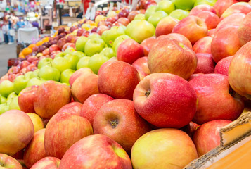 Apples for sale in a market. Red apples are closest, green apples farther away. shallow dept of field.