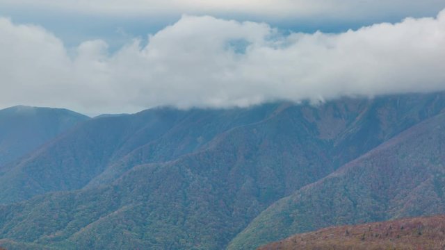 Timelapse of Sea of Clouds over Fall Colored Mountain Range -Tilt Down-