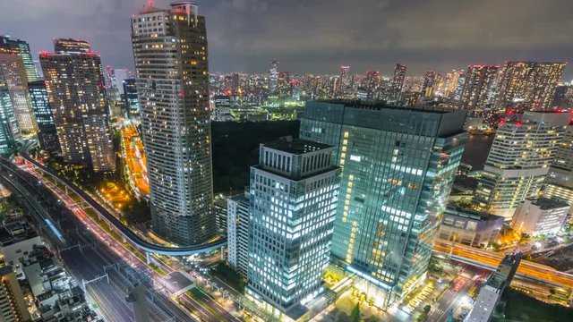 Timelapse Overview of City Transit below Tokyo Skyline at Night -Pan Left-