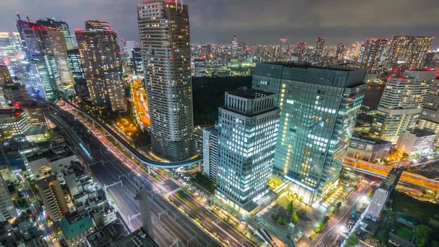 Timelapse Overview of City Transit below Tokyo Skyline at Night -Zoom In-