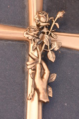 Rose in hand on the tombstone,bronze  ,  cross engraving