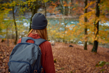 woman with backpack in the forest in yellow autumn