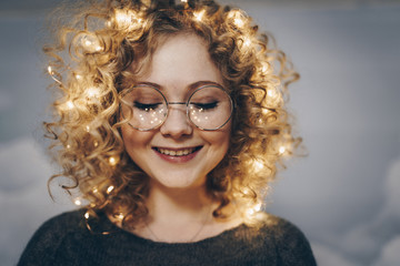 cute young girl with curls and garlands in her hair. freckles from garlands - 243969680