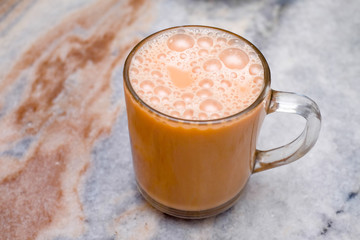 Teh tarik or pulled tea is a famous sweet milk tea in Malaysia. Bubble is floating on the surface of teh tarik.