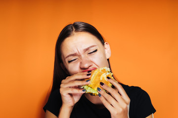 hungry girl wants to lose weight, but eagerly eats a harmful burger