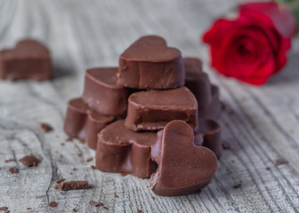 Bombones de chocolate en forma de corazón con flor roja