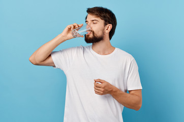 man drinking water from a glass on a blue background