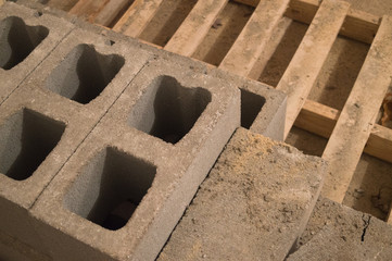 Solid and hollow concrete blocks stacked on a wooden pallet.