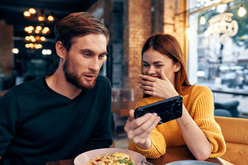 young couple with a phone cafe