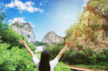 Woman relaxing by tree sky Asian girl Enjoying the nature . Young woman arms raised enjoying the...