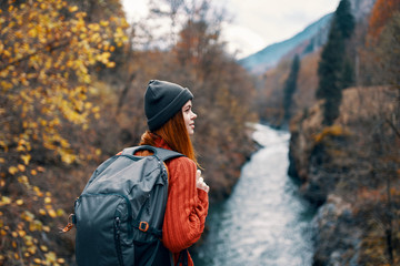 woman with a backpack in the woods by the river trip