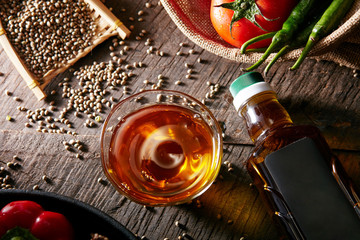 Closeup poured oil in glass bowl on wooden table in kitchen