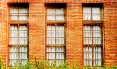 Red window brown wood wall.Detail of colorful window on old traditional house
