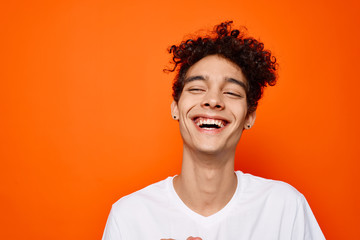 african man with curls smiling on orange background