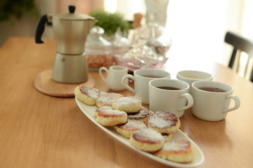 geyser coffee maker and syrniki for breakfast for a family of cups on the table